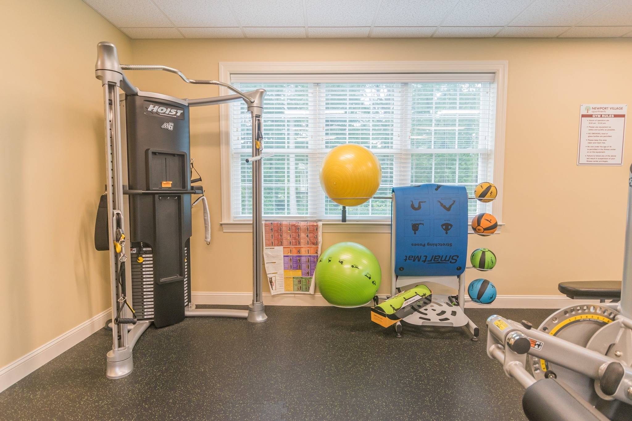 Indoor gym with yoga balls and other workout machines for residents at Newport Village Apartments.