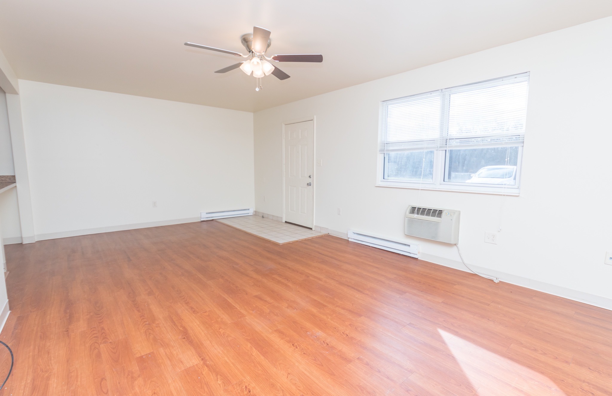 Spacious living and dining area with a ceiling fan and 2 windows.