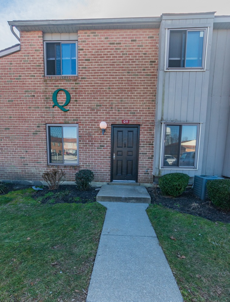 Exterior of a townhome in Woodbury, NJ with a yard and a walkway to the entrance.