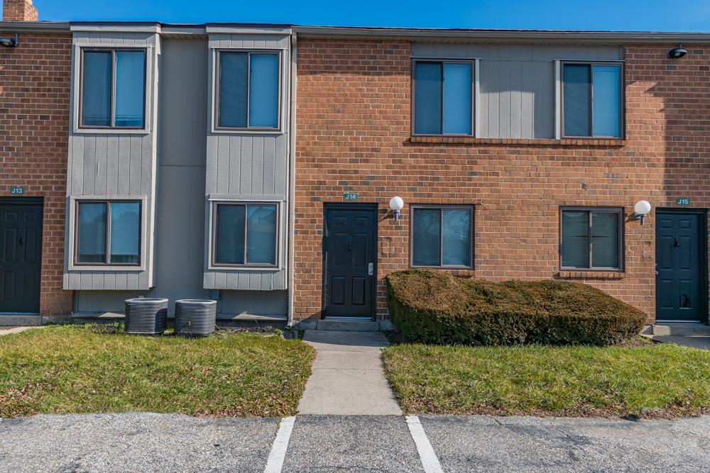 Exterior of a townhome in Woodbury, NJ with parking spaces in front of the townhome.