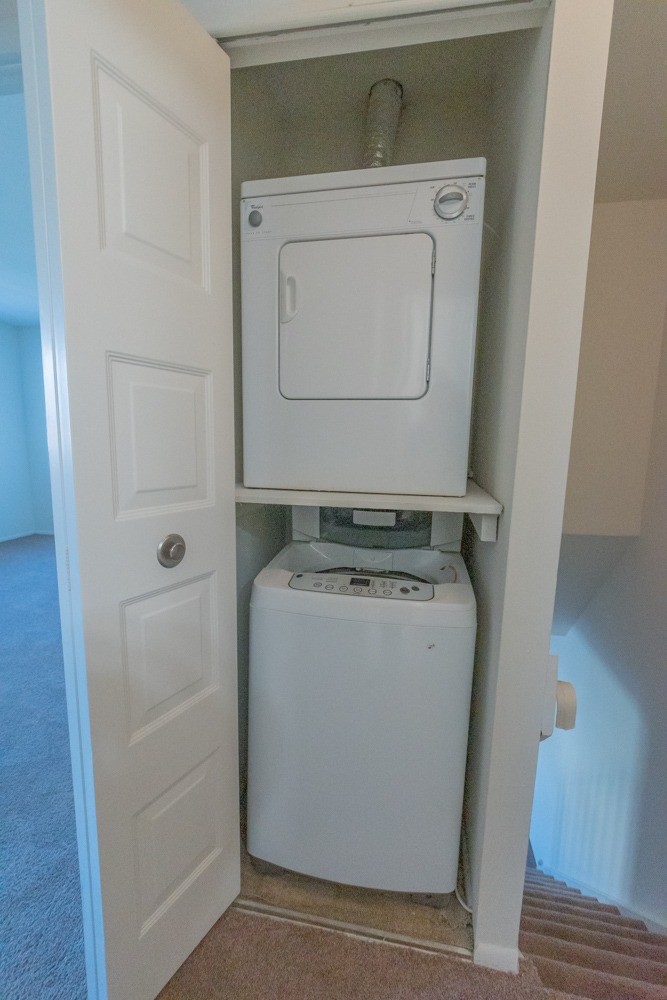 Closet with a washer and dryer inside of it.