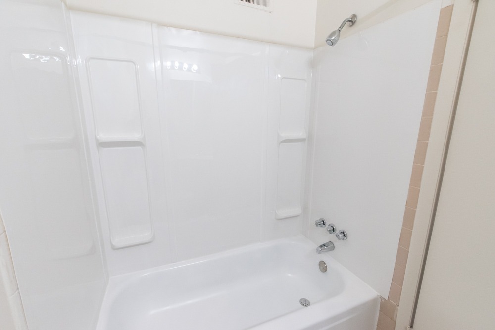 Bathtub with white tiles in a bathroom at Red Bank Run Townhomes.