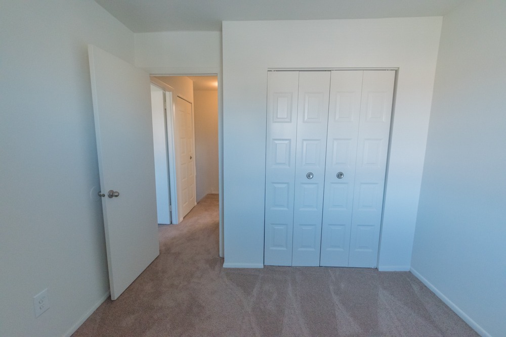 Carpeted bedroom with a closet at Red Bank Run Townhomes.