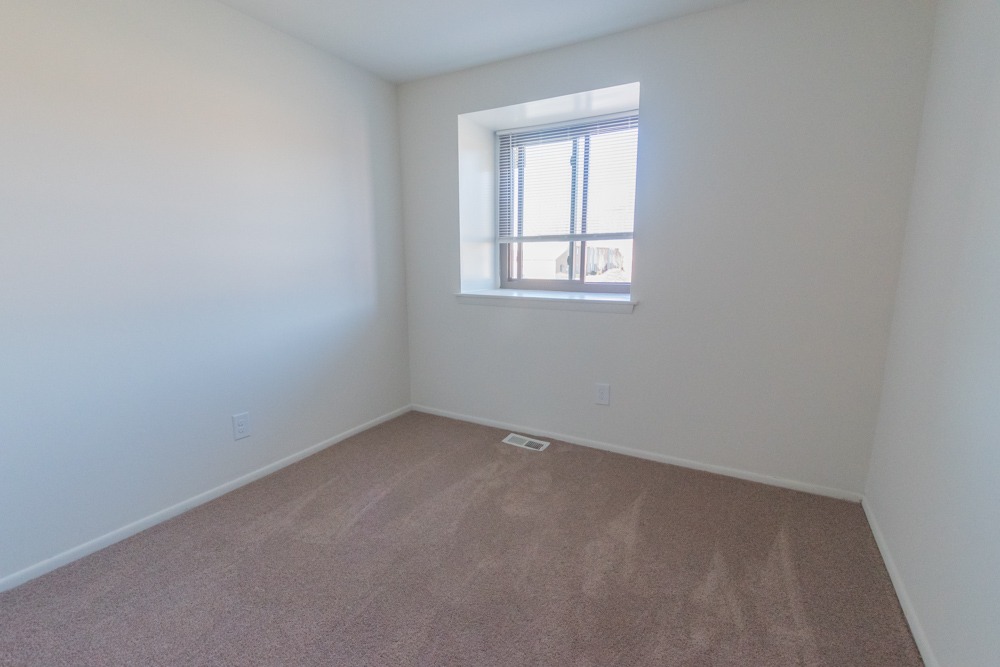 Carpeted bedroom with a window at Red Bank Run Townhomes.