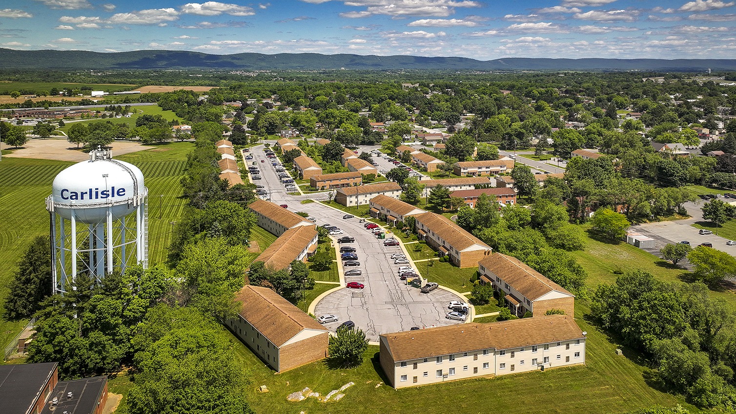 Aerial view of Carlisle Park apartments with a water tower on the left side