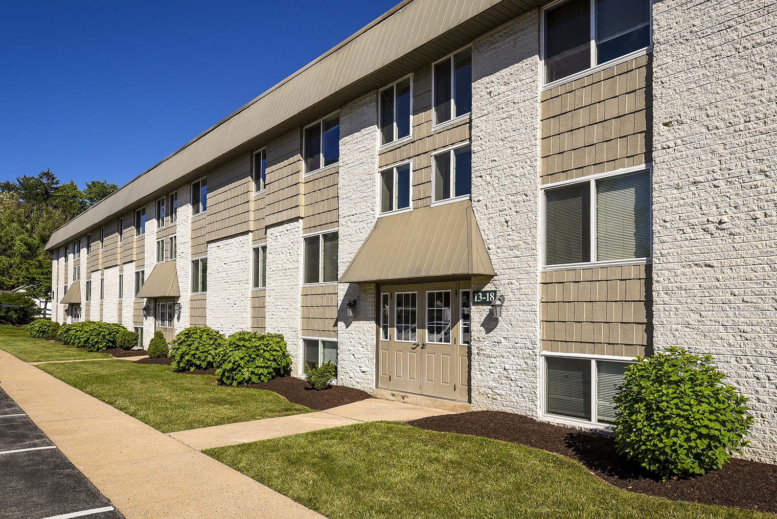 Exterior view of Park Court Womelsdorf apartments with landscaping and sidewalk in front