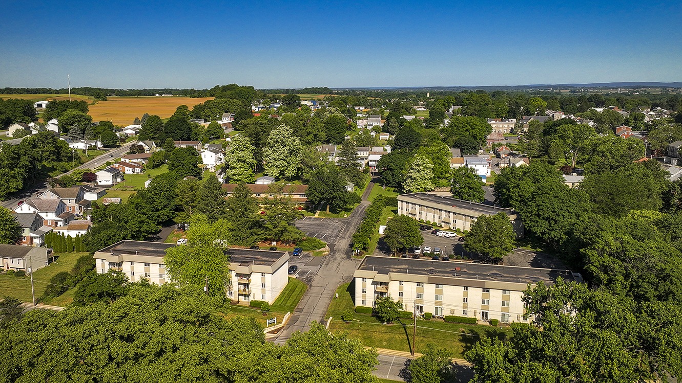 Park Court aerial view of apartments, trees, and the surrounding Womelsdorf area